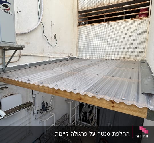 גג עץ עם כיסוי פלסטיק ליד מזגן